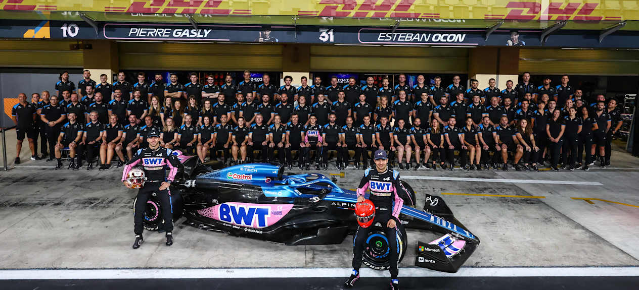 The entire BWT Alpine F1 team and support photographed with Pierre Gasly and esteban Ocon resting on an A523 car in front