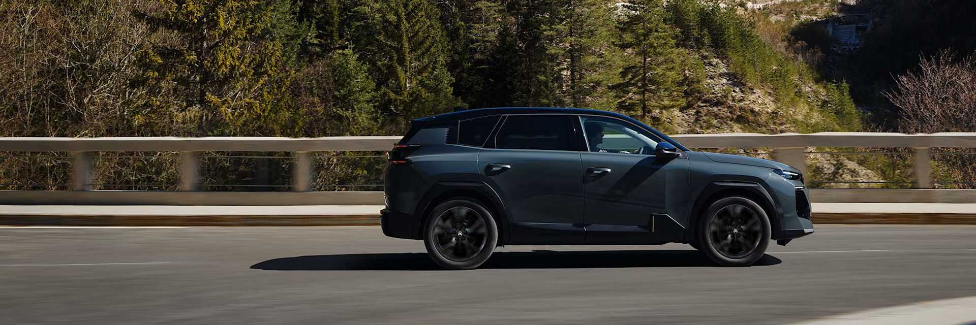 Citroen Aircross side profile driving along road with forest background