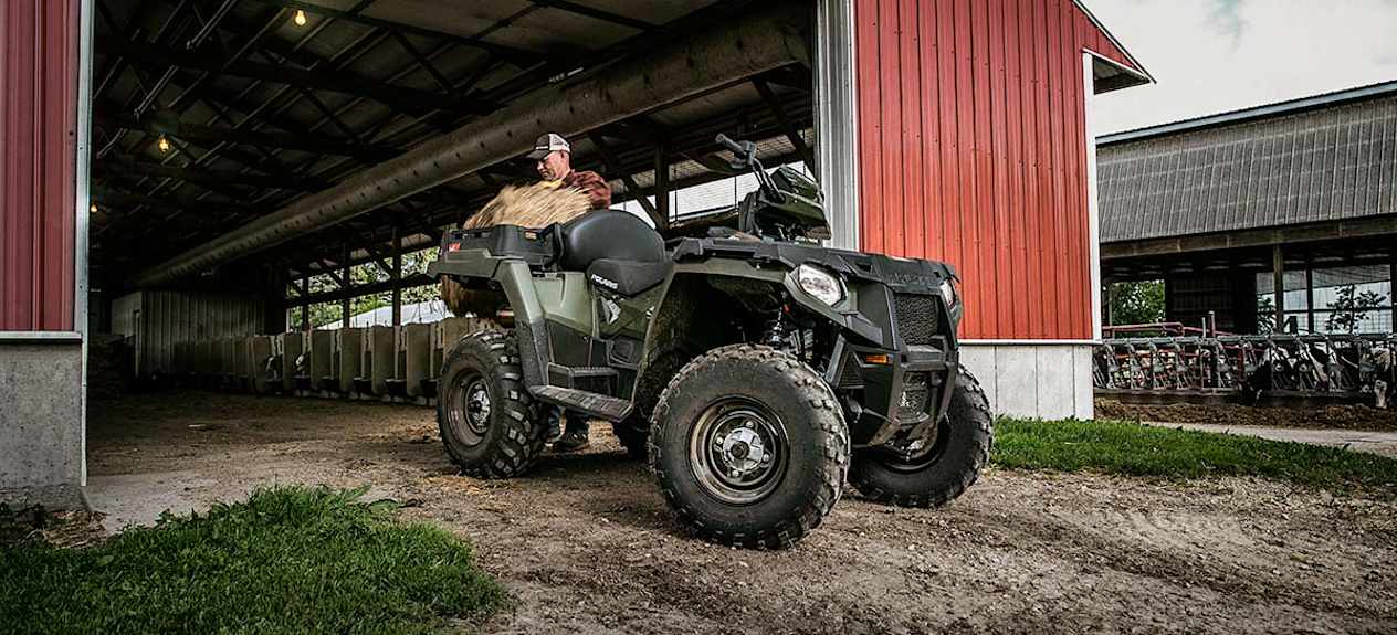 Polaris Sportsman X2 570 2023 : trois quarts avant droit devant une ferme