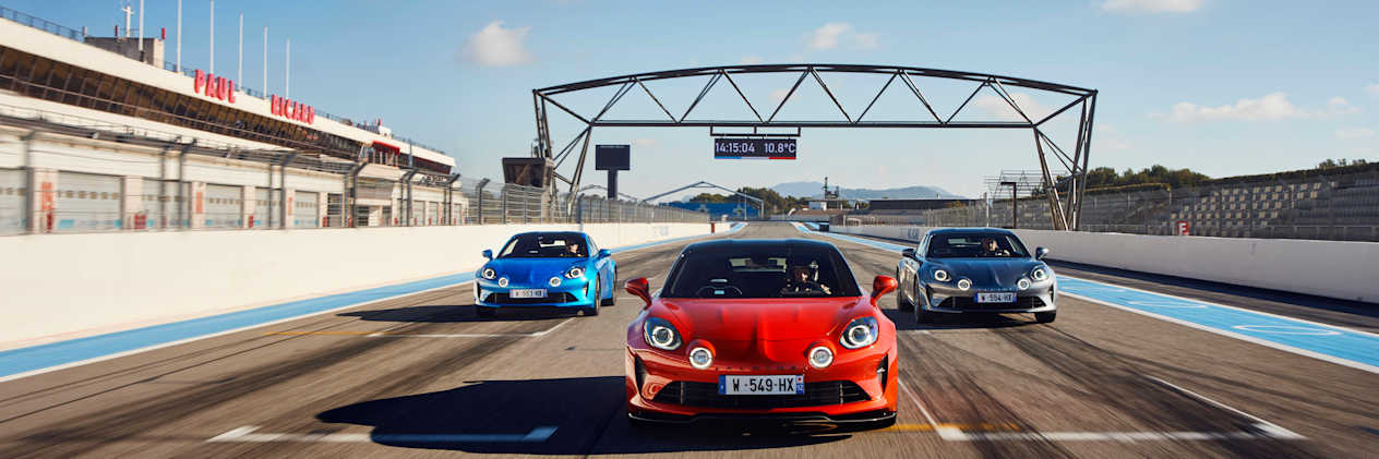 The Alpine A110 range drives on a track towards the camera.