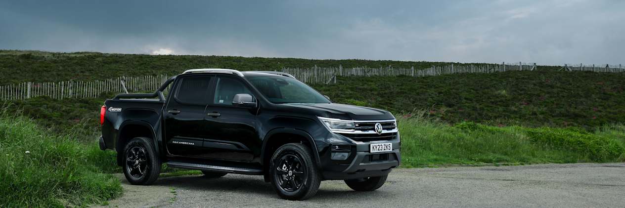 Side on view of the black Volkswagen Amarok with the Scottish hills in the background