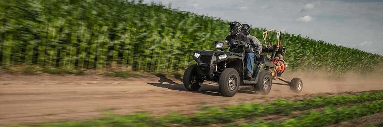 Polaris Sportsman X2 570 2023 : trois quarts avant sur chemin avec remorque