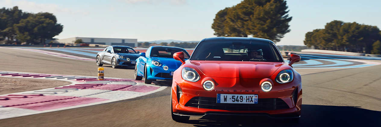 The Alpine A110 range on a track driving towards the camera.