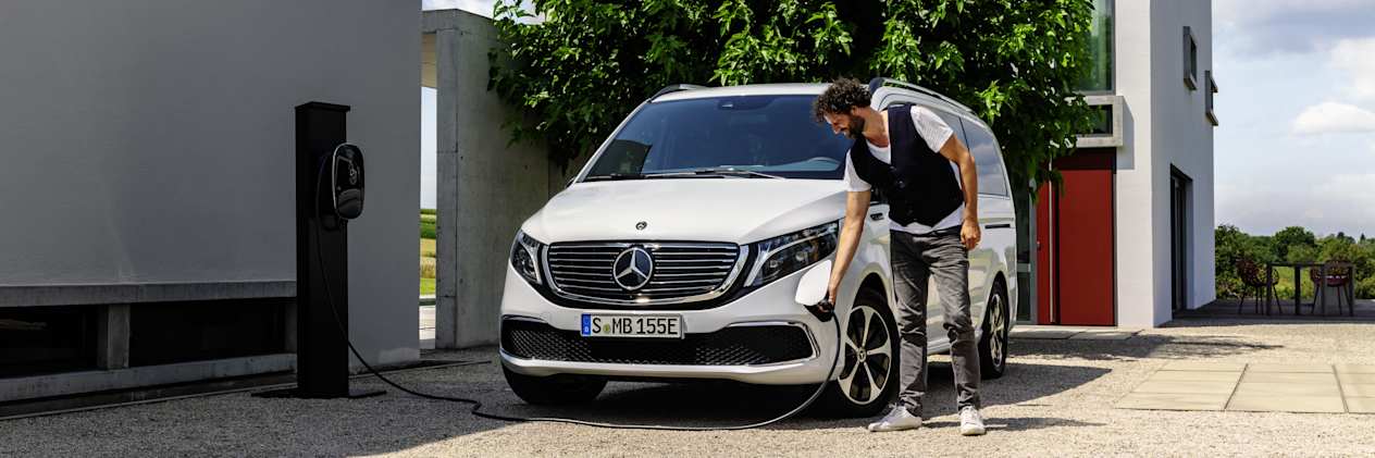 EQV de Mercedes-EQ : Face avant avec une homme branchant la prise de recharge