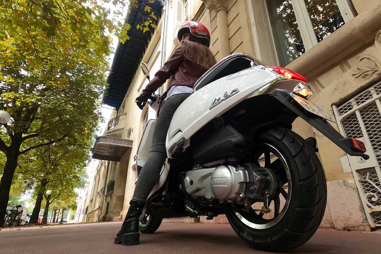 Kymco Like 50 2024 : vue trois quarts arrière gauche avec gros plan sur moteur
