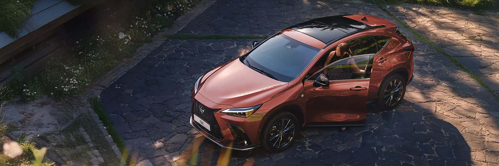 Lexus NX in courtyard with woman getting in left side