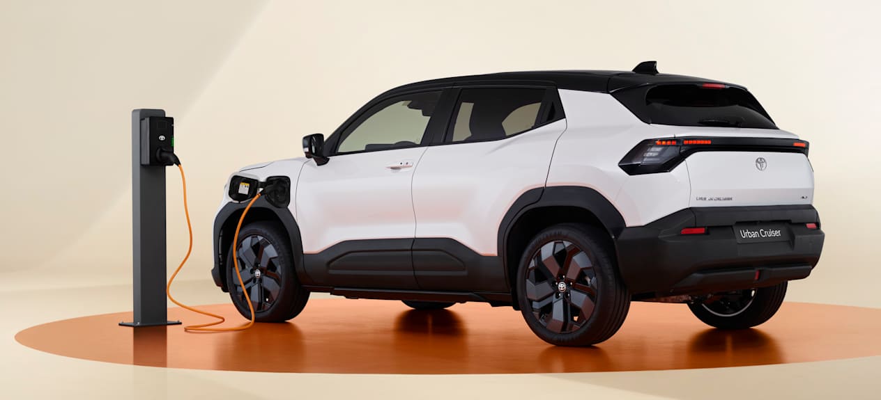 Toyota Urban Cruiser 2025 : trois quarts arrière gauche avec borne de recharge