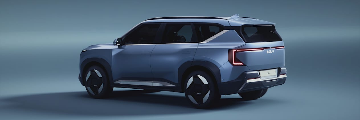 Kia EV5 2024 : trois quarts arrière gauche sur fond bleu