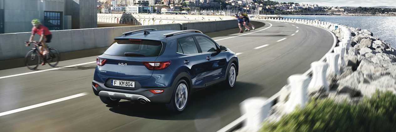 Kia Stonic 2021 : trois quarts arrière droit sur route en bord de mer