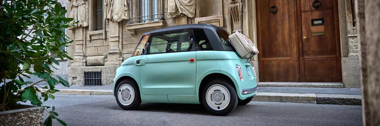 Fiat Topolino 2023 : trois quarts arrière gauche devant bâtiment ancien