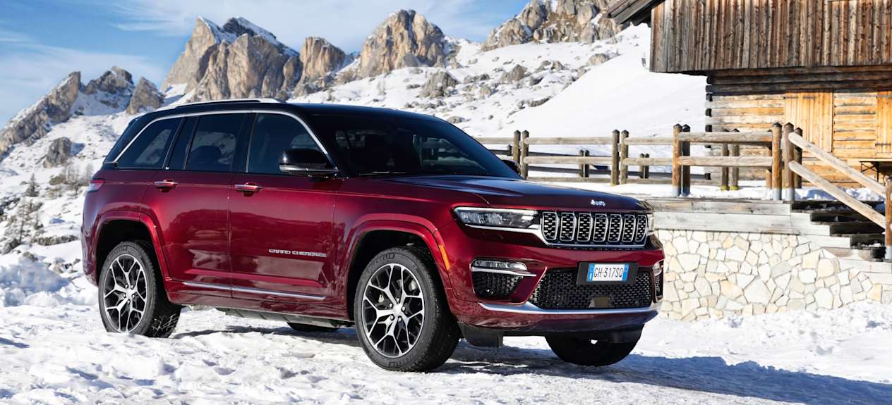 Jeep Grand Cherokee 2022 : trois quarts avant garé devant un chalet