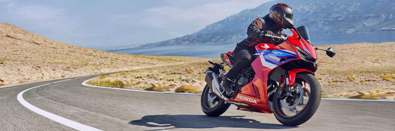 Honda CBR500R 2024 : trois quarts avant droit sur route dans le désert
