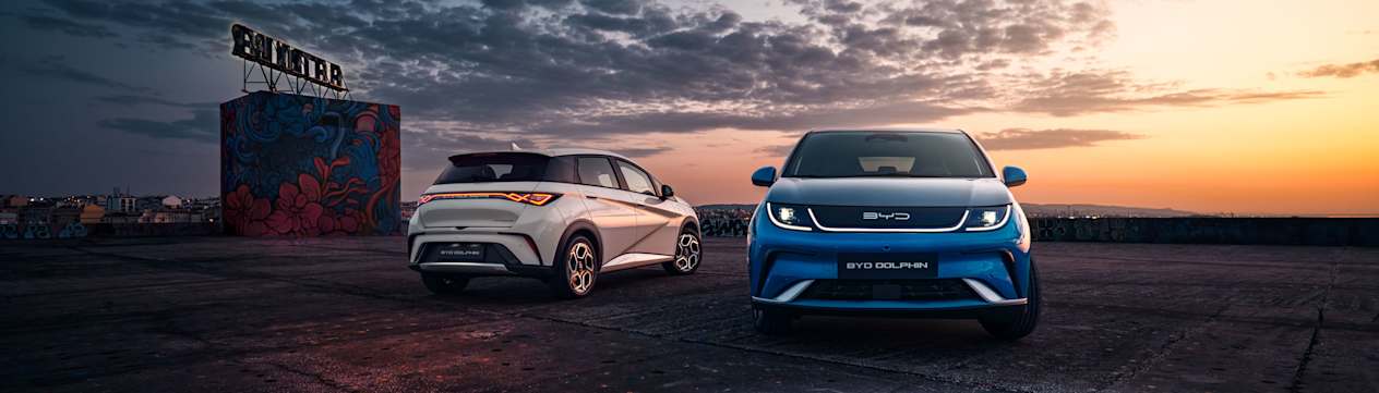 BYD Dolphin 2023 : couleur Surfing Blue face avant et Cream White face arrière devant coucher de soleil