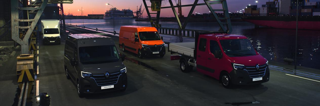 A variety of Renault Master vans driving across a bridge at night