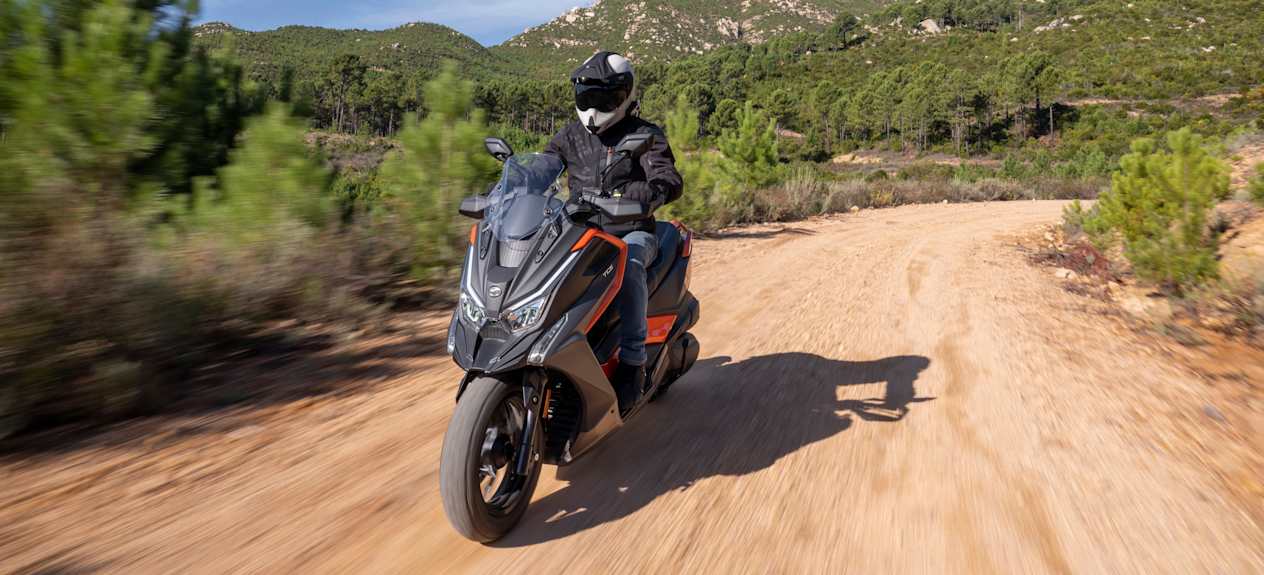 Kymco DTX 360 2024 : trois quarts avant gauche sur chemin de terre