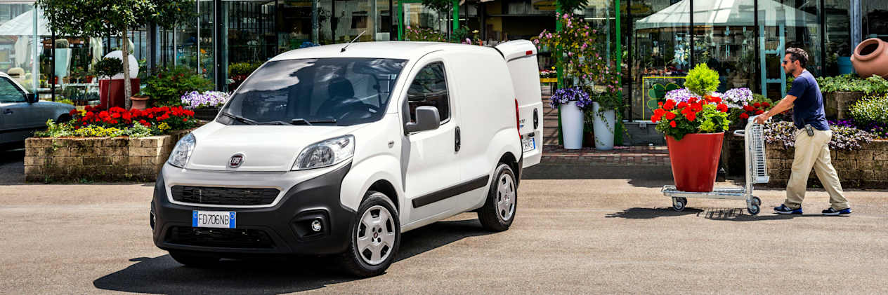 Fiat Fiorino blanc chargement devant une jardinerie
