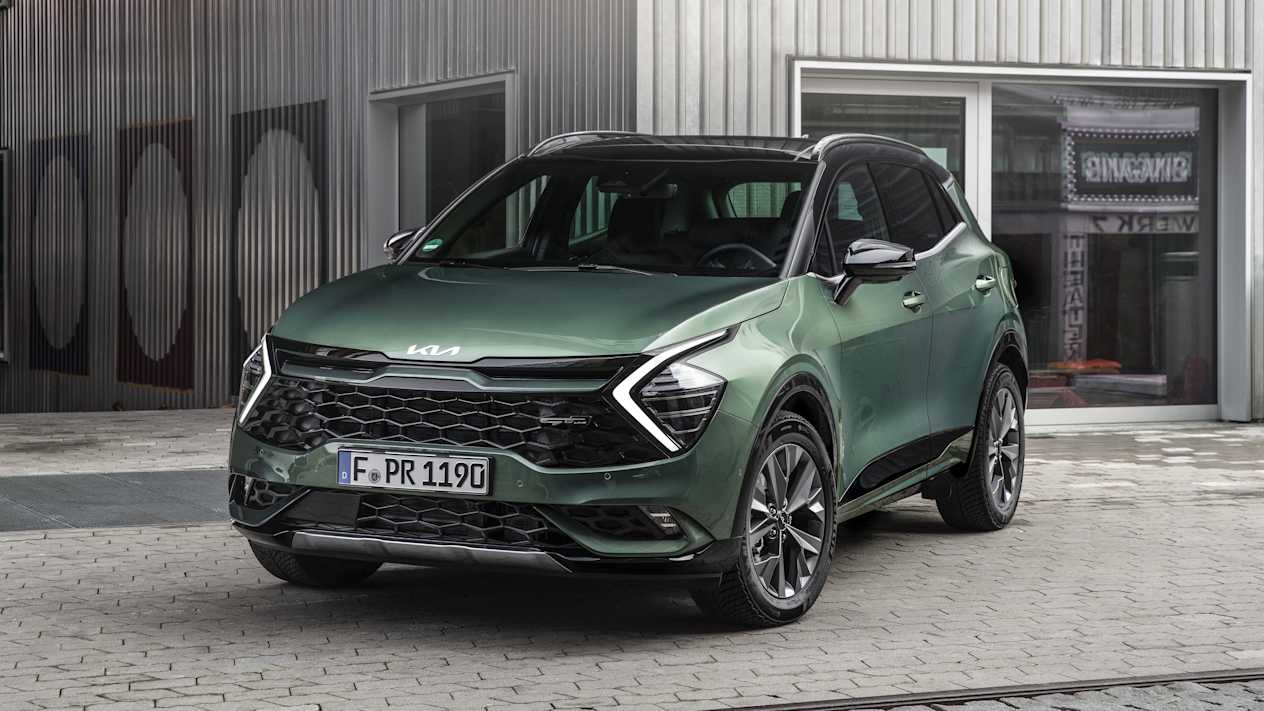 Kia Sportage 2022 : Trois quart avant vert devant une devanture