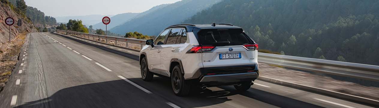 Toyota RAV4 Hybride : trois quarts arrière gauche sur route de montagne