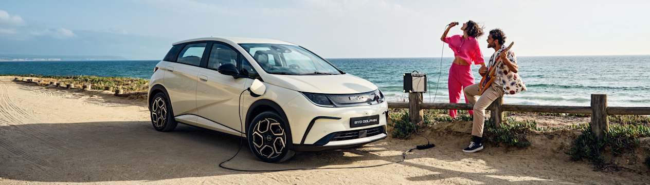 BYD Dolphin 2023 : trois quarts avant droit en charge en bord de mer avec couple