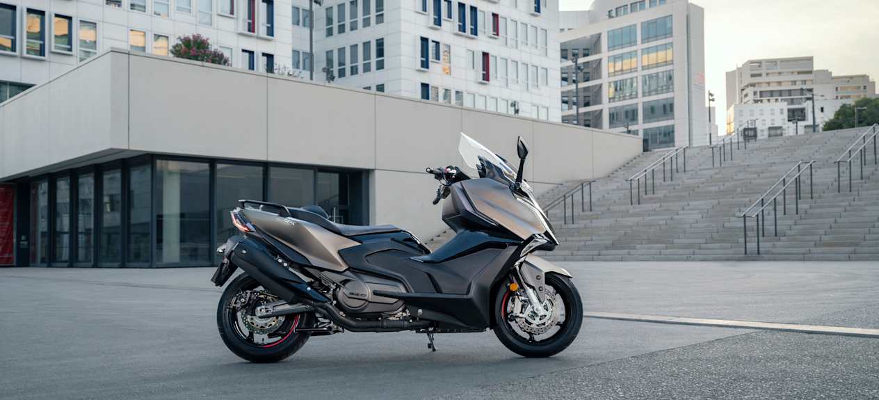 Kymco AK Premium 2024 : profil droit statique devant escaliers