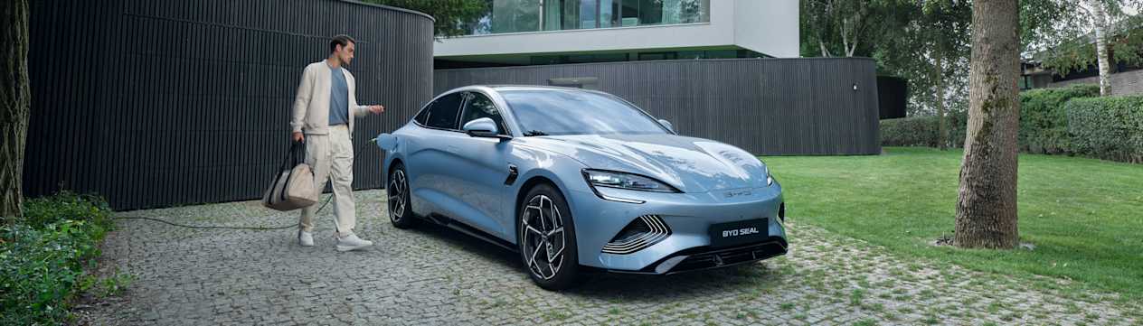 BYD Seal 2023 : trois quarts avant droit statique en charge dans le jardin d'une villa
