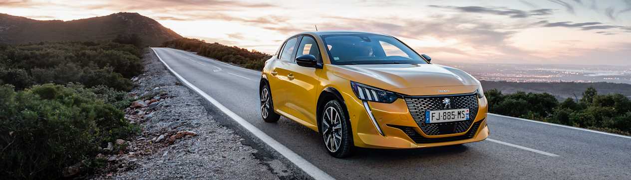 Peugeot 208 2020 jaune trois quarts avant droit sur coucher de soleil