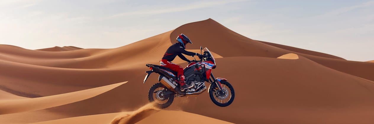 Honda Africa Twin CRF1100L 2024 : vue profil droit saut au-dessus d'une dune