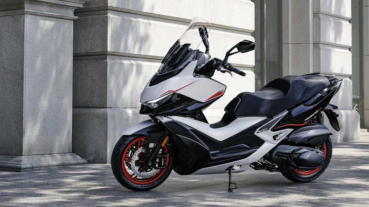 Kymco Xciting VS 400 SE 2024 : profil gauche statique devant bâtiment