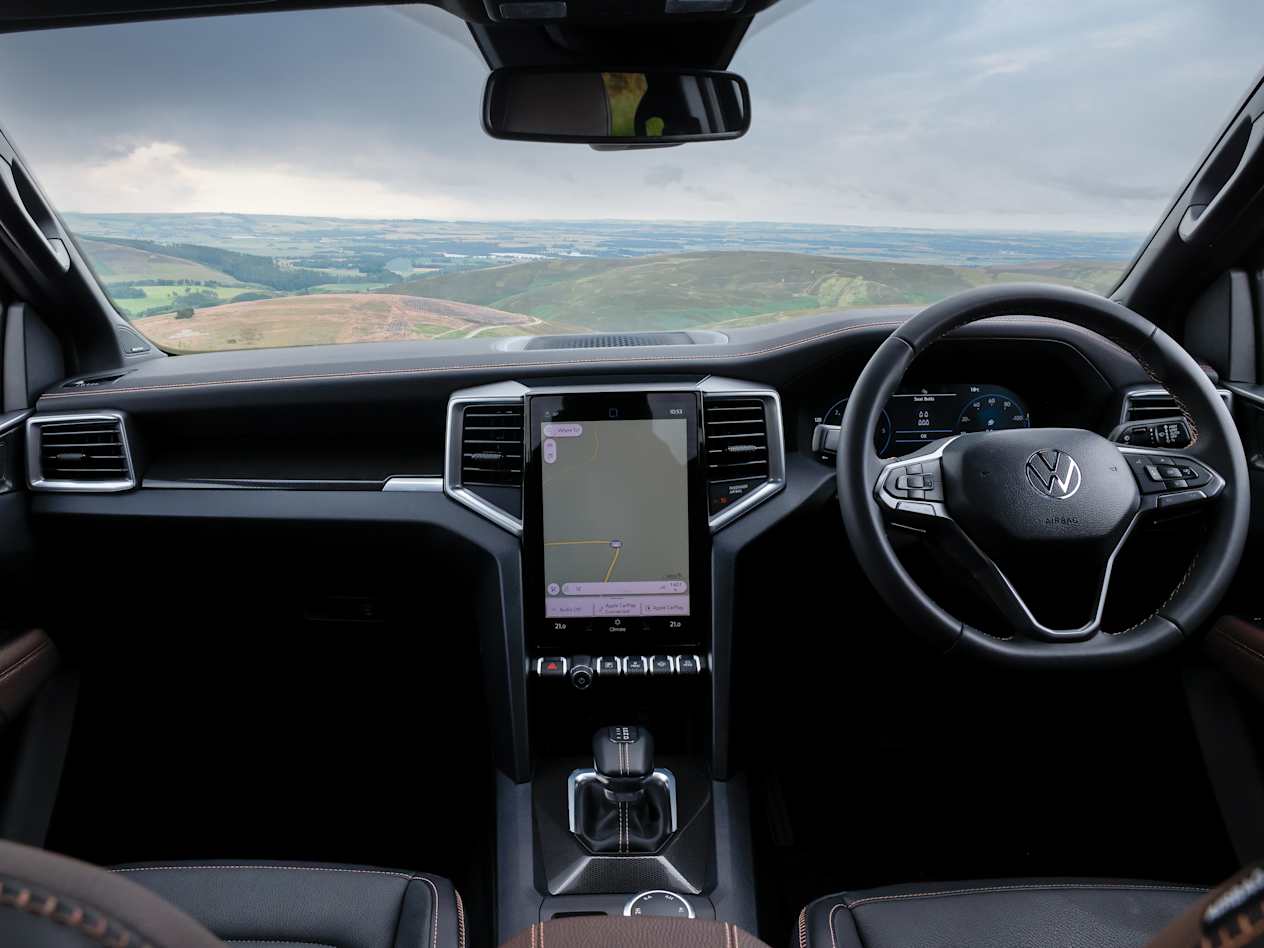 Interior of the front seats of theVolkswagen Amarok showing the driving controls and touchscreen system