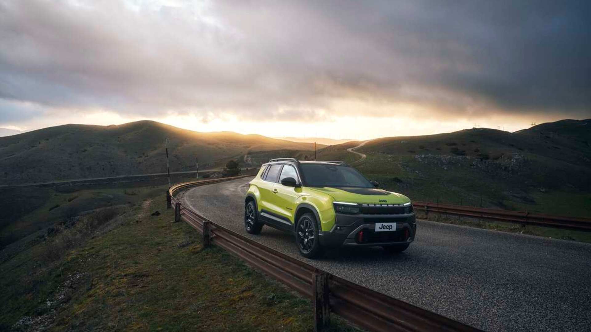 the new avenger driving down a winding road, with a sunset background