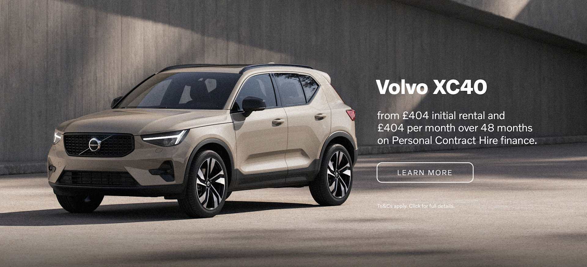 A Volvo XC40 parked against a modern concrete backdrop, showcasing its sleek design and features.