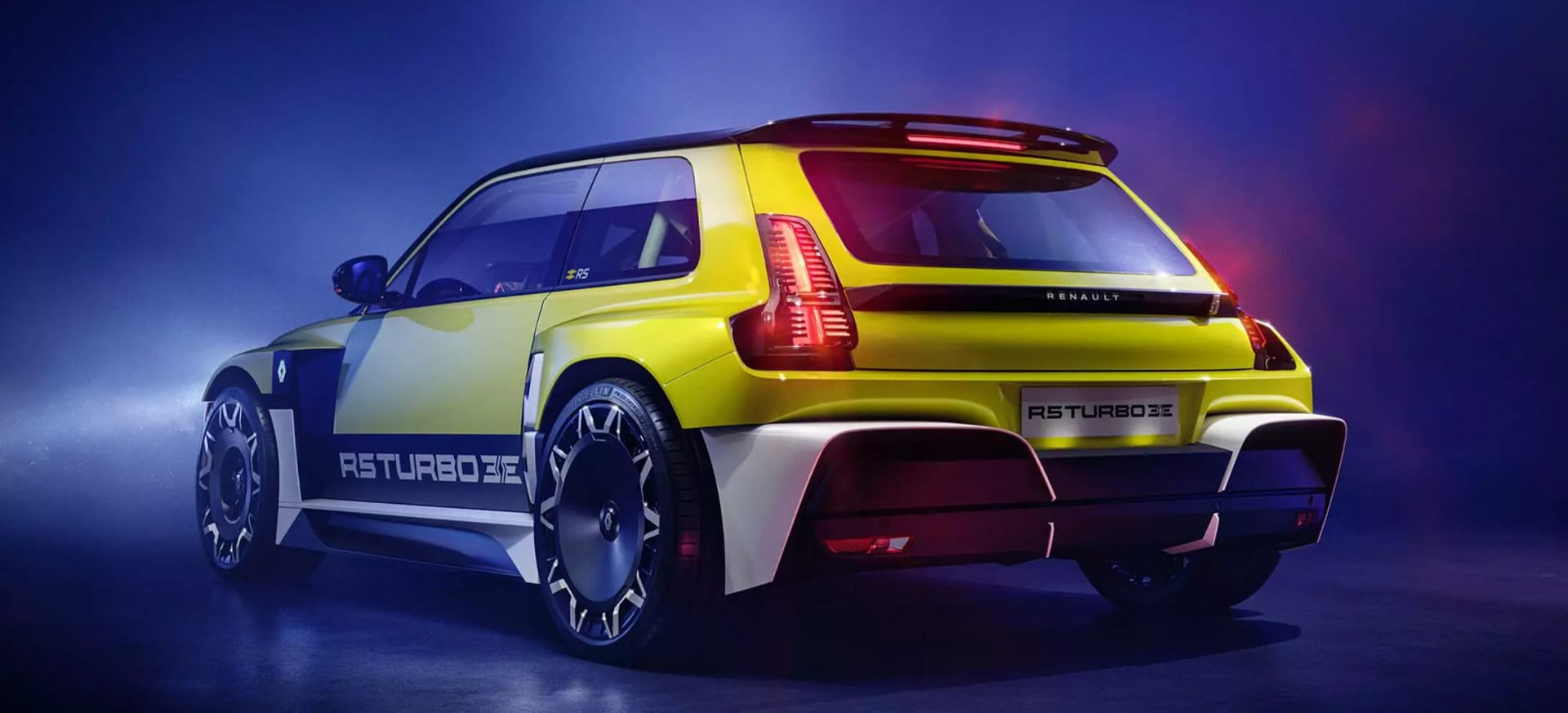 A vibrant yellow Renault 5 Turbo 3E with a sporty design, illuminated against a dark background.