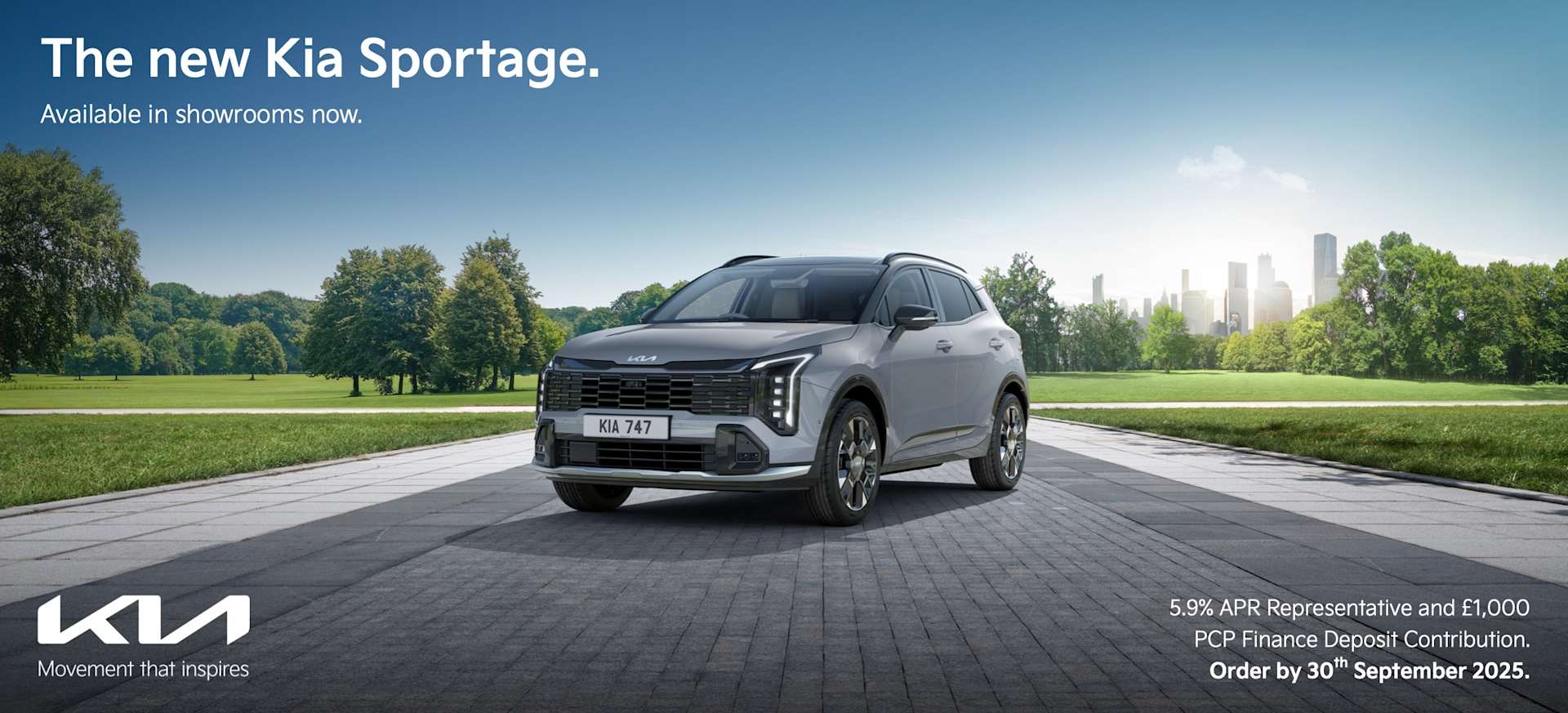 A new Kia Sportage parked on a paved area with greenery and a city skyline in the background.