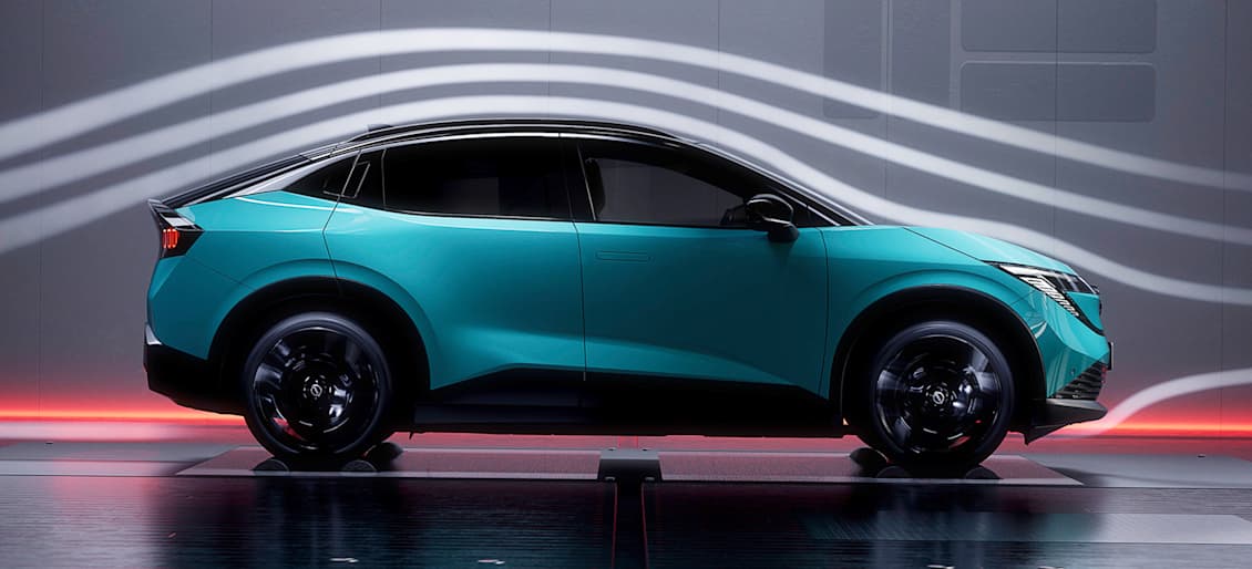 A side view of a modern electric Nissan LEAF in a vibrant turquoise colour, aerodynamic lines and dark background