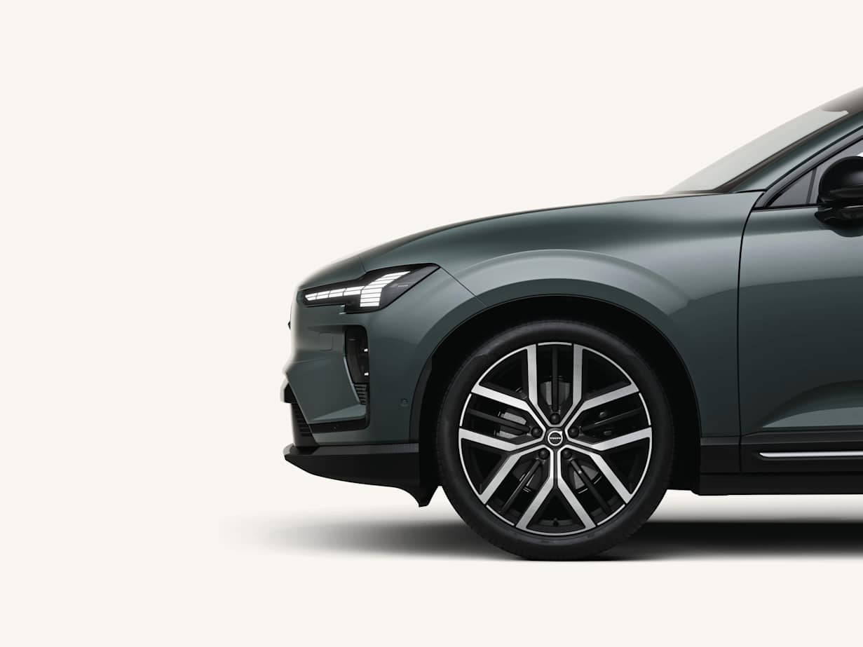 Side view of a sleek, modern Volvo EX60 in a dark green colour, showcasing its alloy wheel and design details.