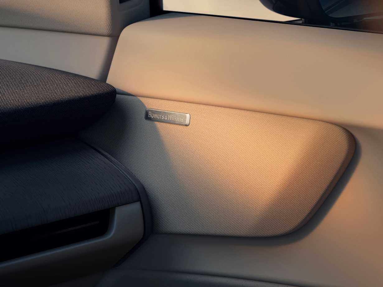 Close-up of a Volvo EX60 interior featuring textured surfaces and a Bowers & Wilkins speaker badge.