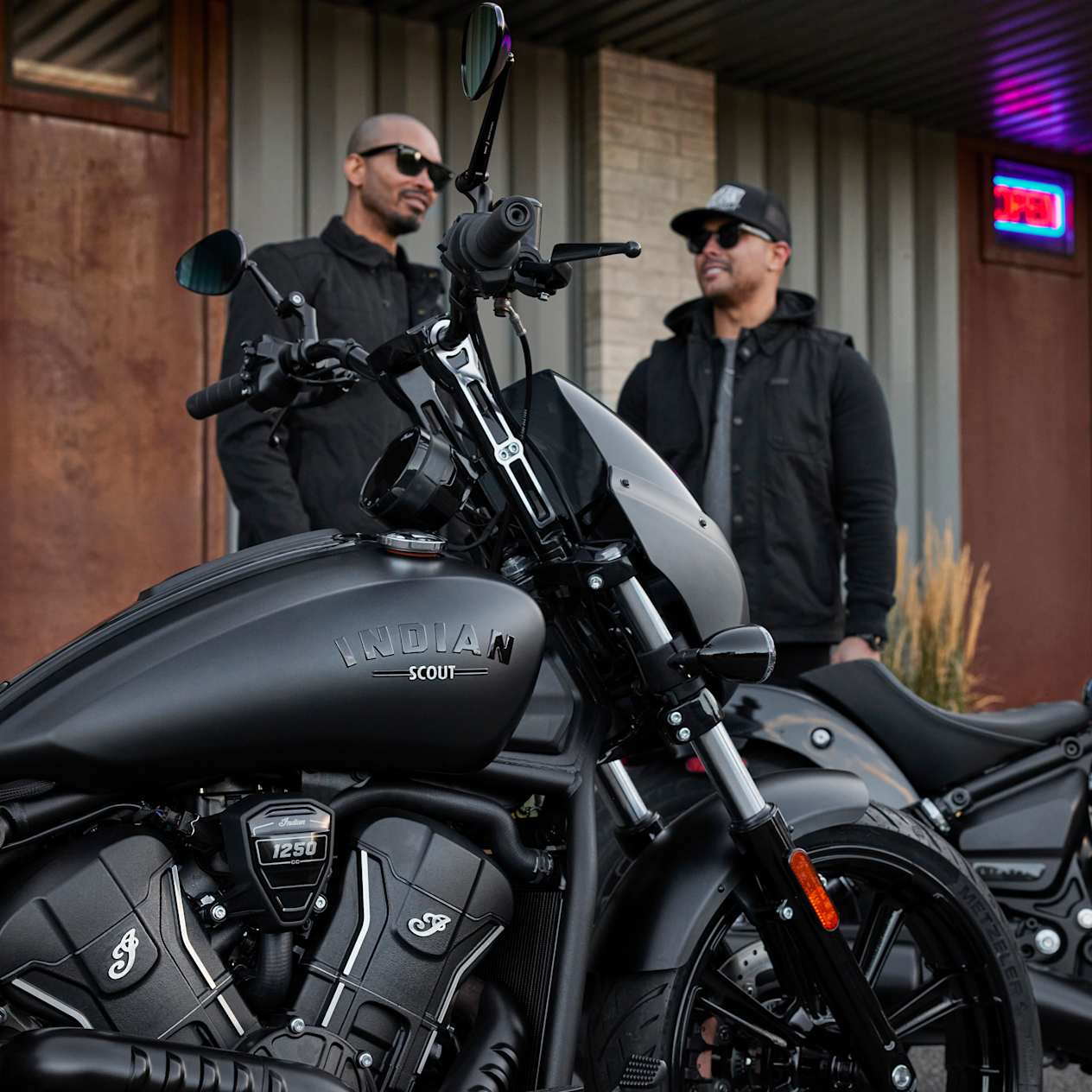 Indian Sport Scout Limited 2025 : Black Smoke vue sur le réservoir en gros plan avec motards au second plan