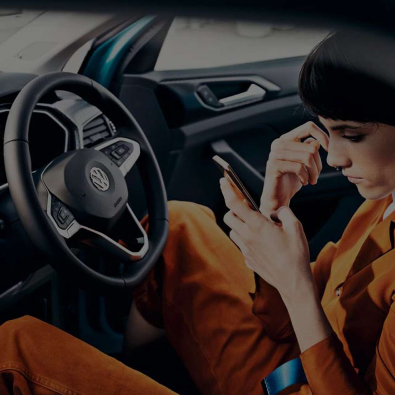 Person in the drivers seat of a Volkswagen whilst on their phone