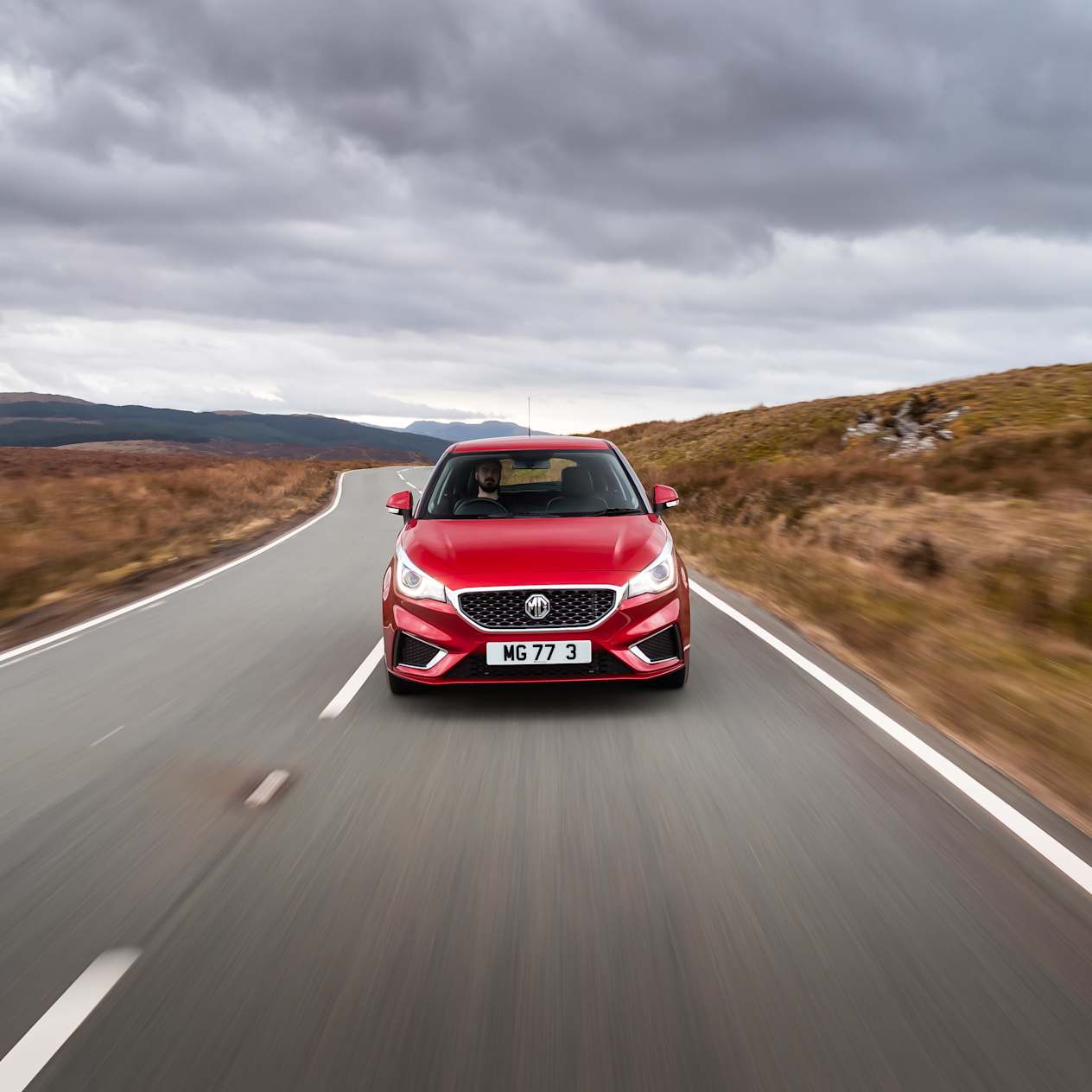 Front view of a red MG3 driving in the countryside