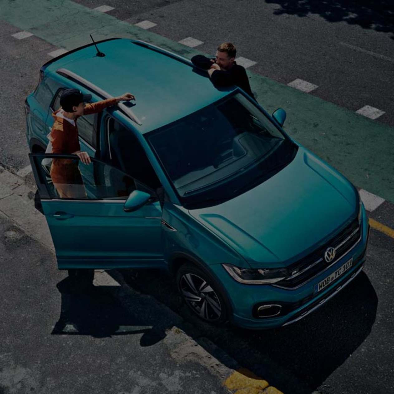 Two people about to enter the blue Volkswagen car 