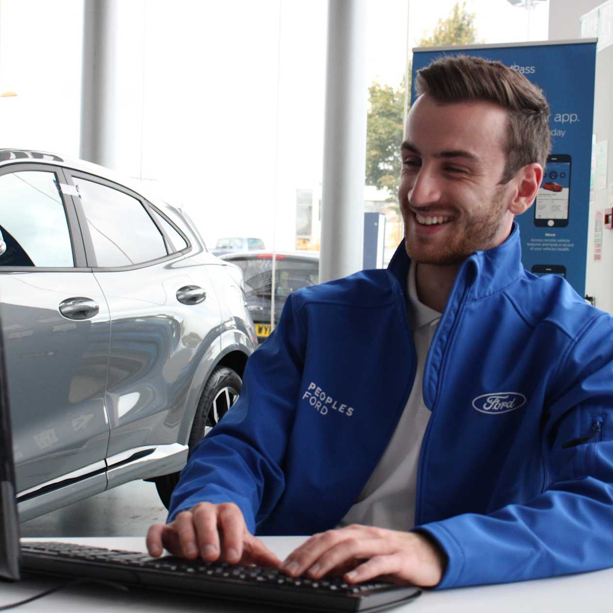 People's Cars - A Happy Sales Executive Typing on a Computer