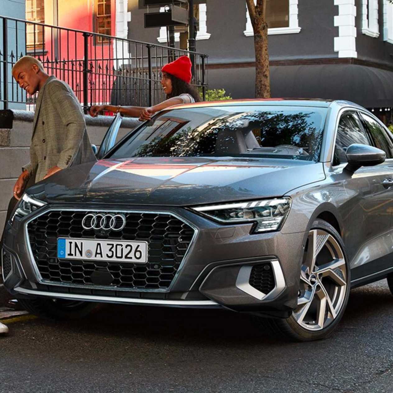Man in green coat sitting on Monsoon grey Audi A3