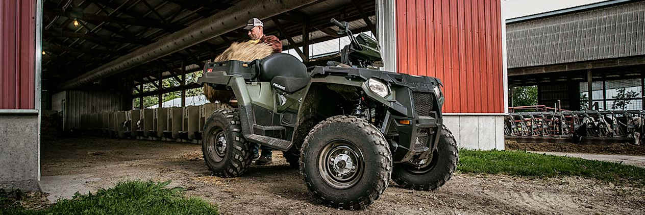 Polaris Sportsman X2 570 2023 : trois quarts avant droit devant une ferme