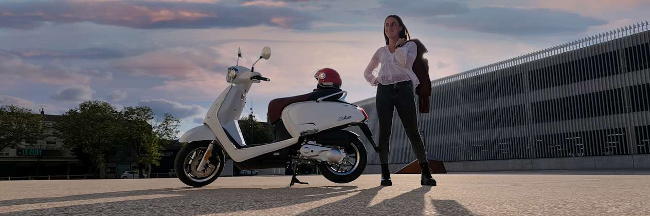 Kymco Like 50 2024 : profil gauche statique avec jeune femme et coucher de soleil
