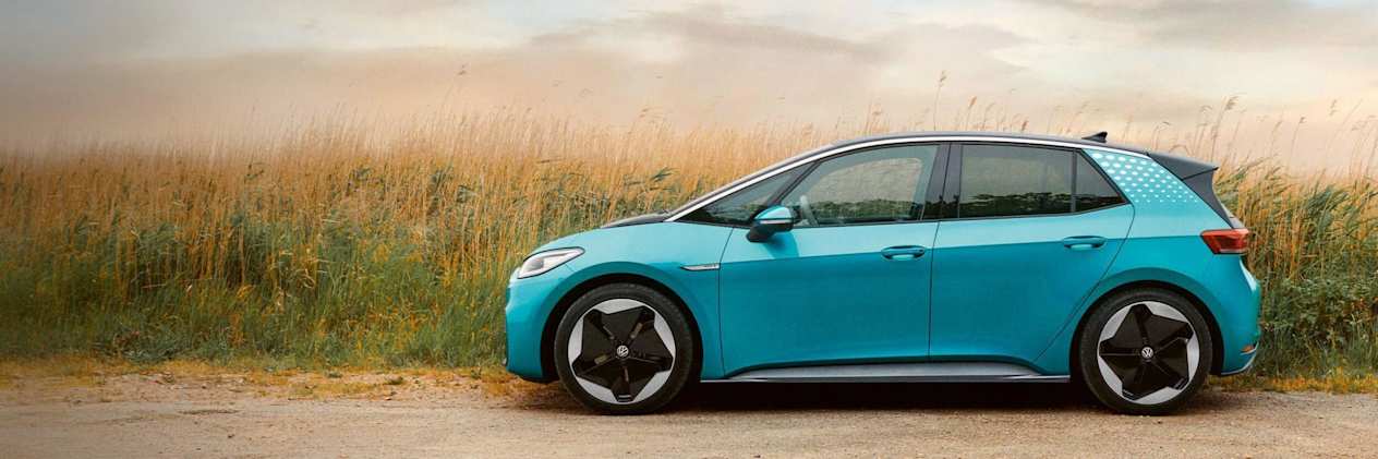 Blue Volkswagen car parked next to a field of corn