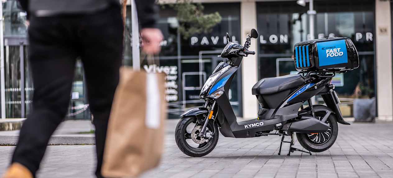 Kymco Agility EV 2024 : profil gauche statique avec livreur