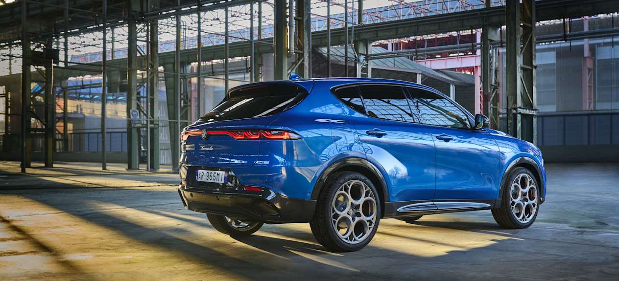 Alfa Romeo Tonale 2022 : Trois quart arri_re avec feucx allumés dans un entrepot