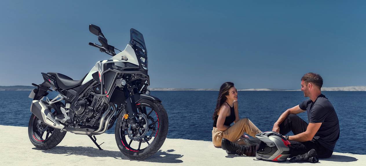 Honda NX500 2024 : trois quarts avant droit en bord de mer avec couple