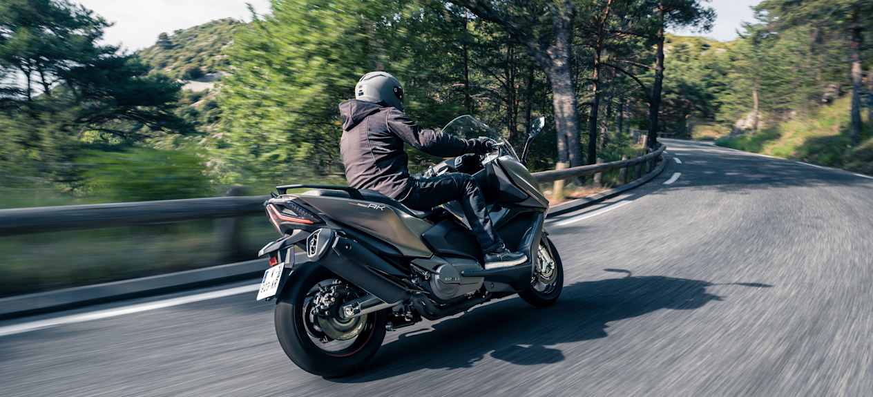 Kymco AK Premium 2024 : trois quarts arrière droit sur route