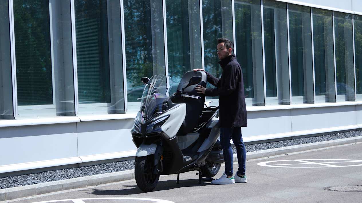 Kymco X.Town City 125 2024 : gris alpin trois quarts avant gauche avec modèle